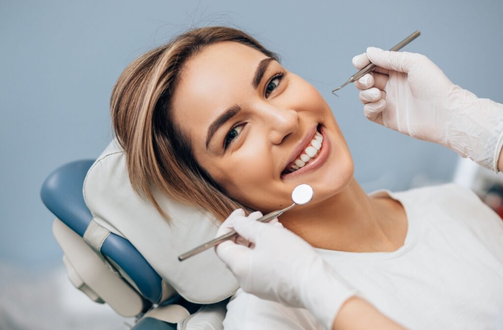 A patient in a dental chair smiling as the dentist is about to work on their teeth
