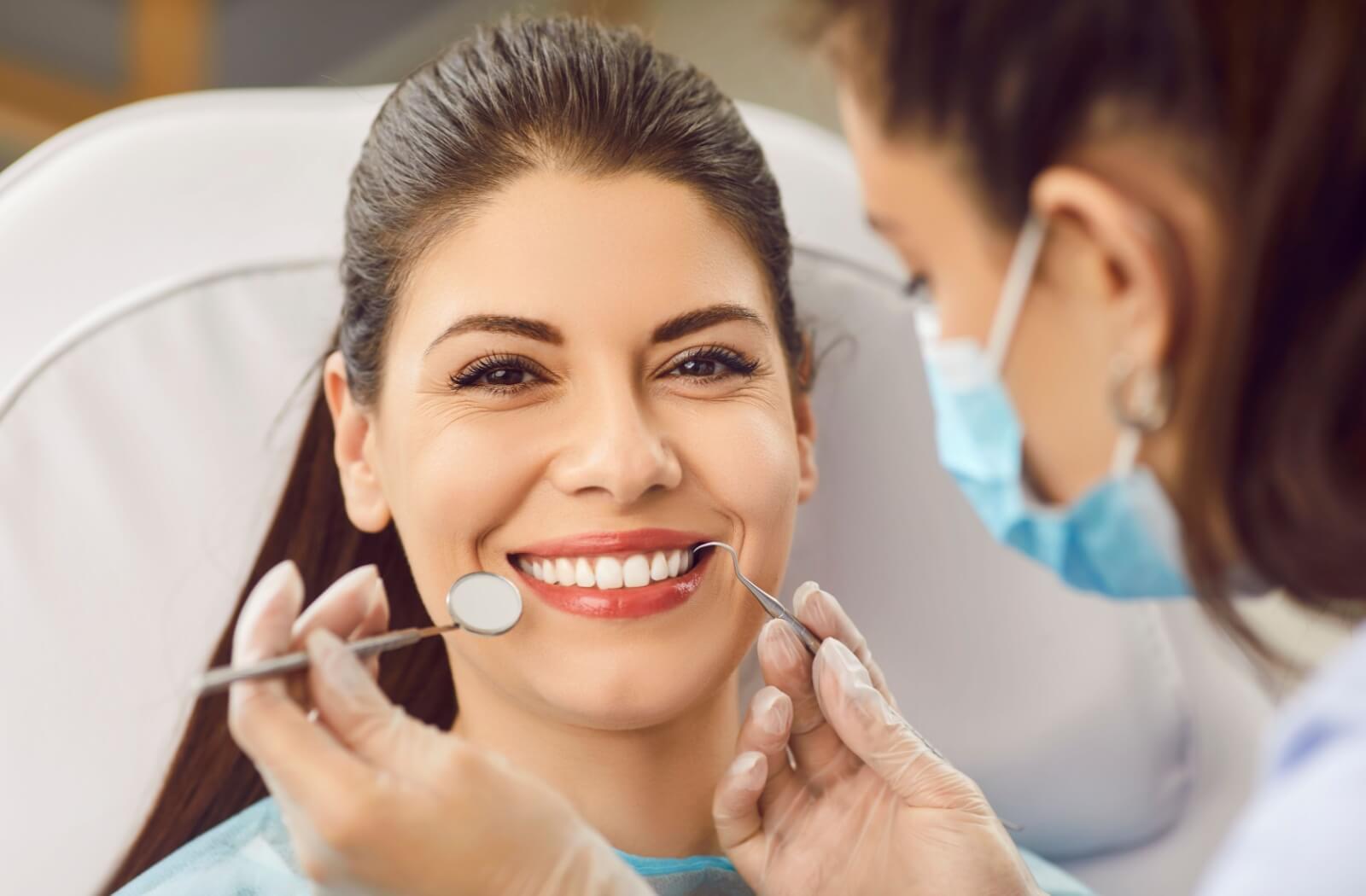 A dental patient smiling as they get their teeth examined.